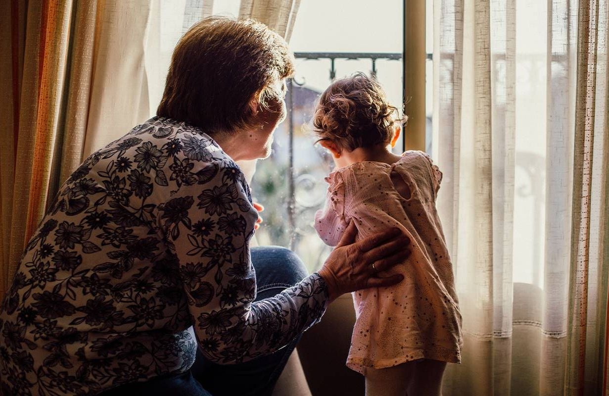A grandmother and her grandchild looking out of the window. Next Avenue, Blended family grandparents