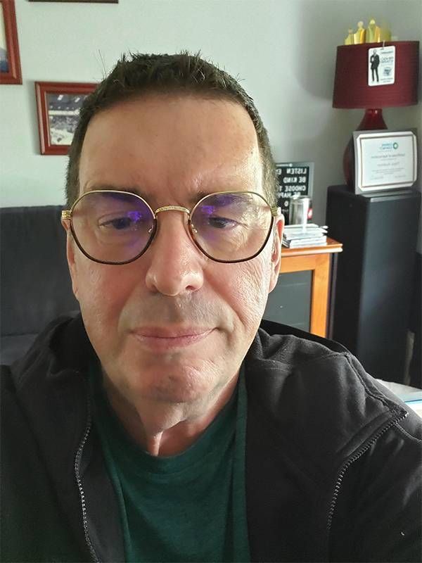 A man wearing glasses at home. Next Avenue, volunteer at suicide hotline