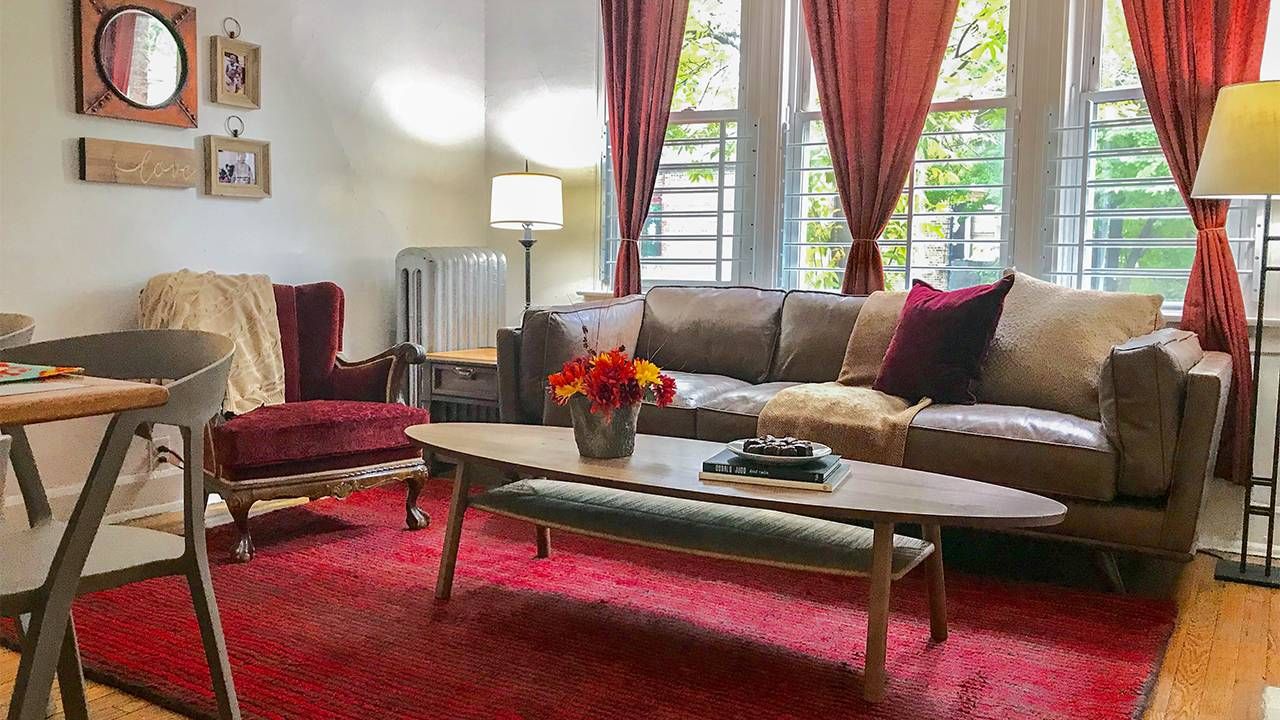 A living room with large windows and red curtains. Next Avenue, how to prevent and end homelessness among older adults