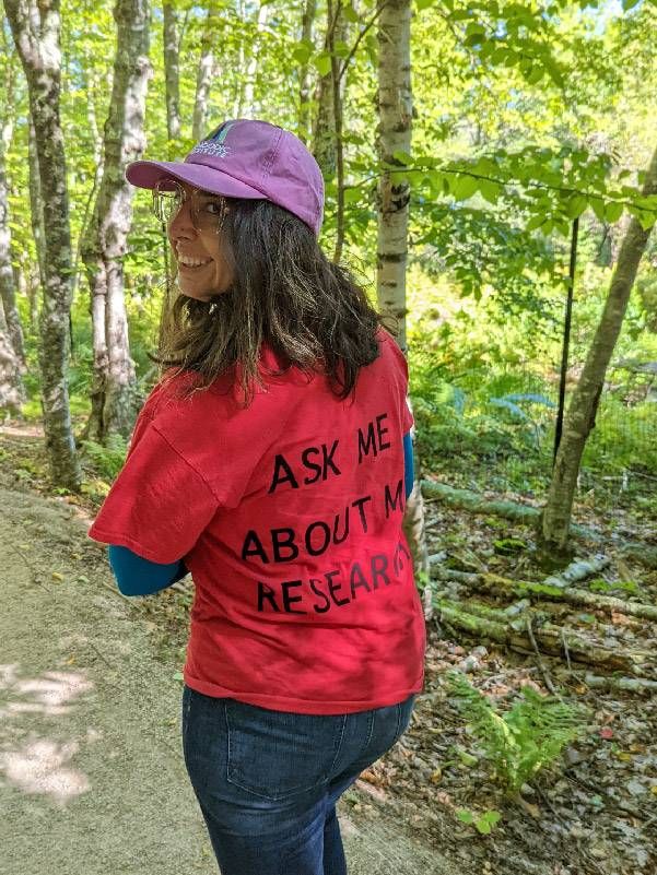 A woman walking down a forested trail. Next Avenue, leaf peeping, peak fall colors