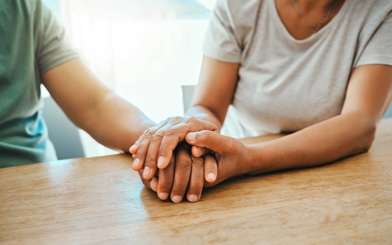 A supportive couple holding hands. Next Avenue, long COVID sexual health