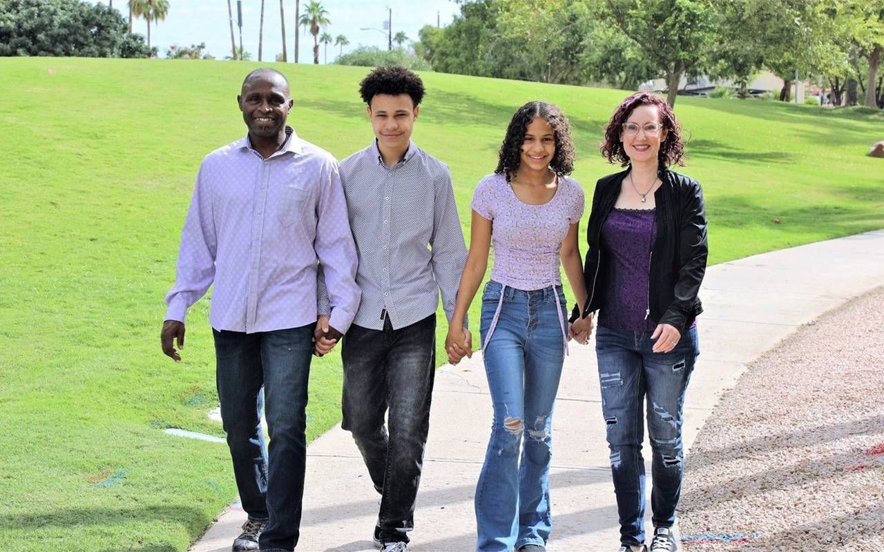 A family holding hands while walking down a path. Next Avenue, kidney failure recovery stories