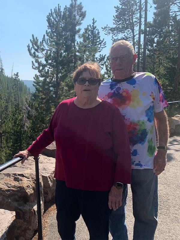 A couple smiling on a hiking trail. Next Avenue, How to travel with older parents