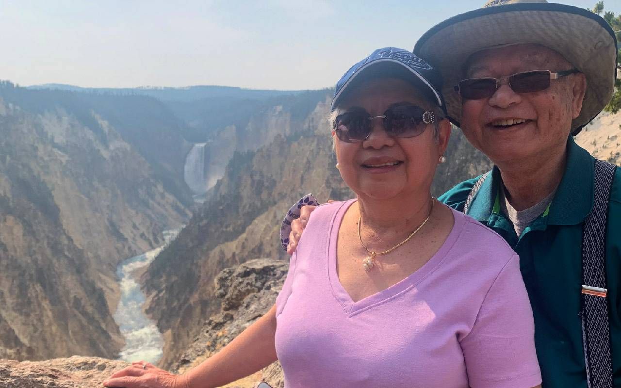 A couple posing in front of a landmark. Next Avenue, How to travel with older parents