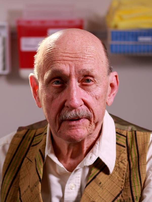 A close-up of a man wearing a vest and button up shirt. Next Avenue, aging well