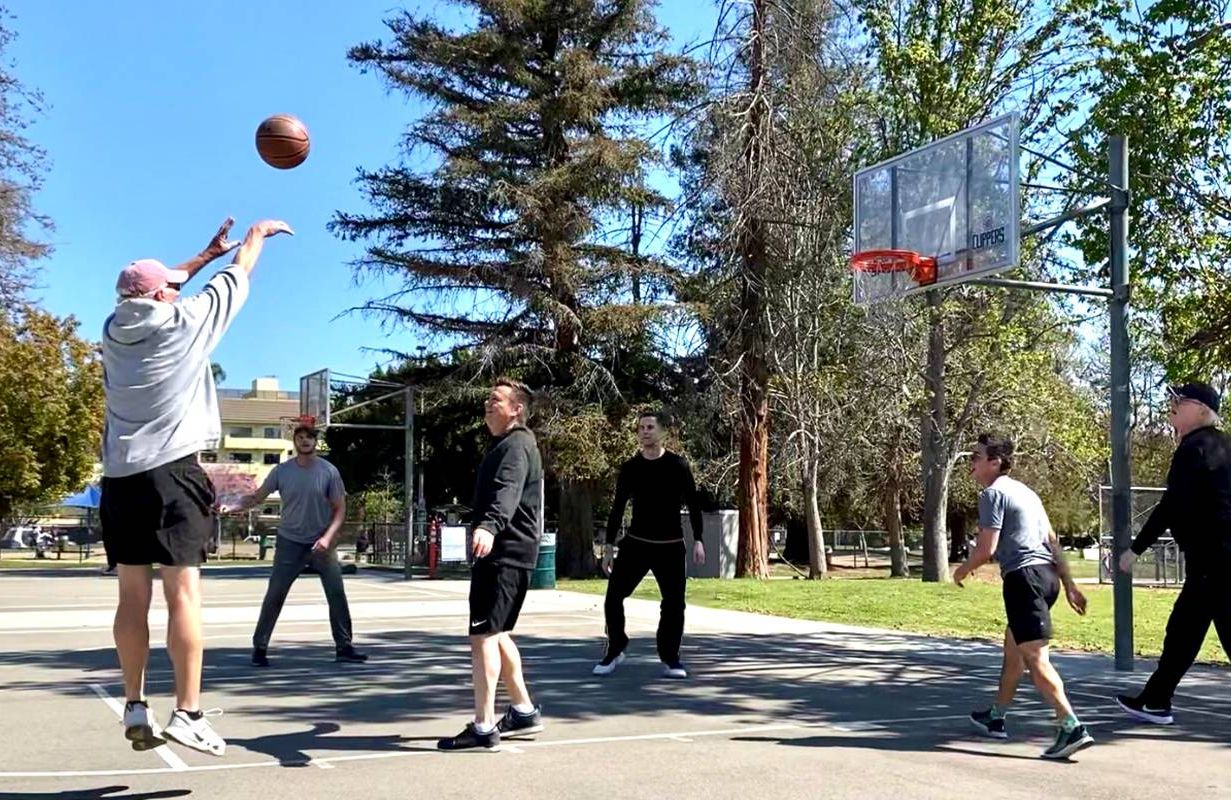 A group of people playing basketball outside. Next Avenue