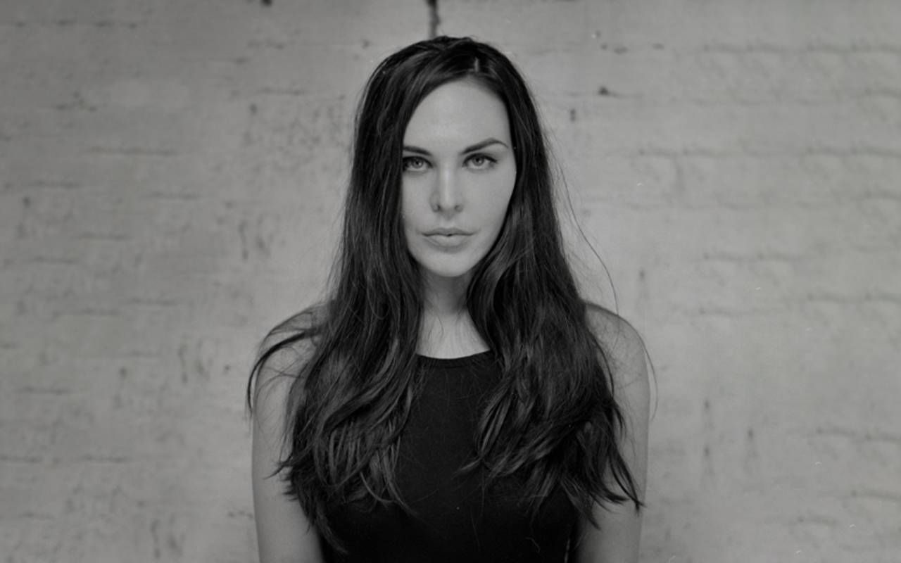 A black and white photo of a woman in front of a brick wall. Next Avenue, hayley campbell, all the living and the dead