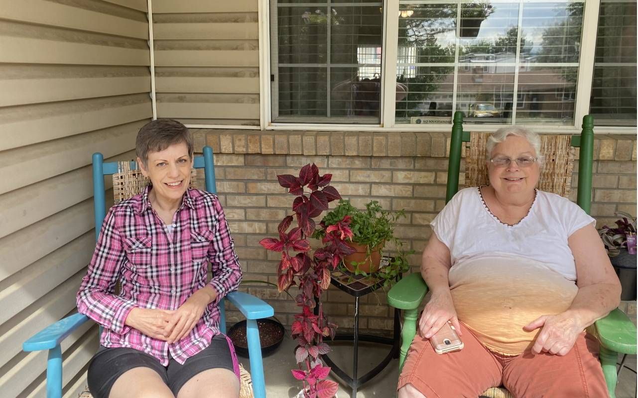 Two baby boomer women sitting in chairs on their front porch. Next Avenue, Baby boomers, roommate, home-sharing