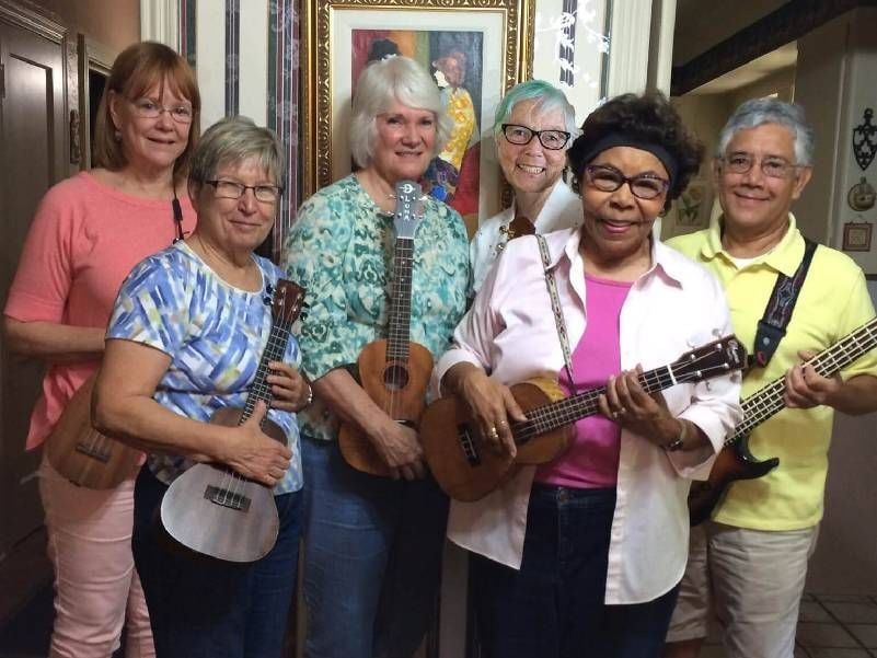 A group of people holding up ukuleles. Next Avenue