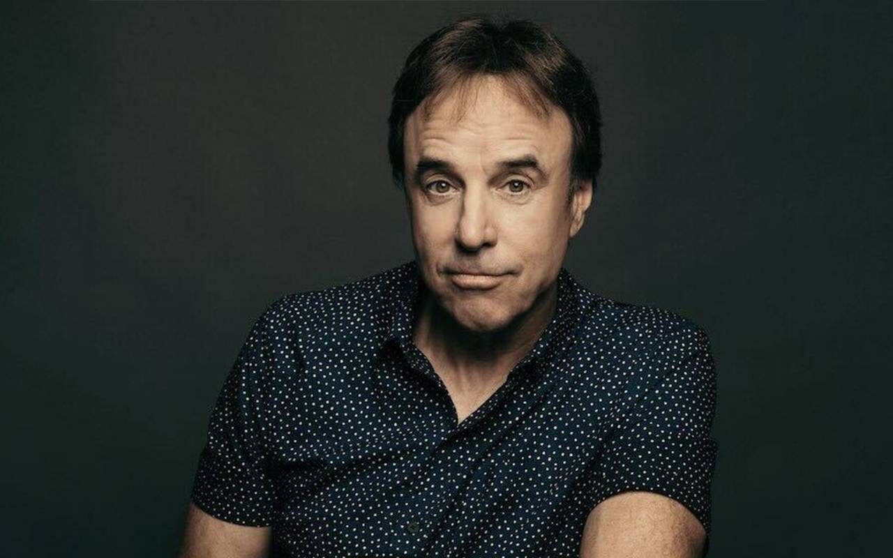 A man wearing a polka dot button up short smiling. Next Avenue, Kevin Nealon