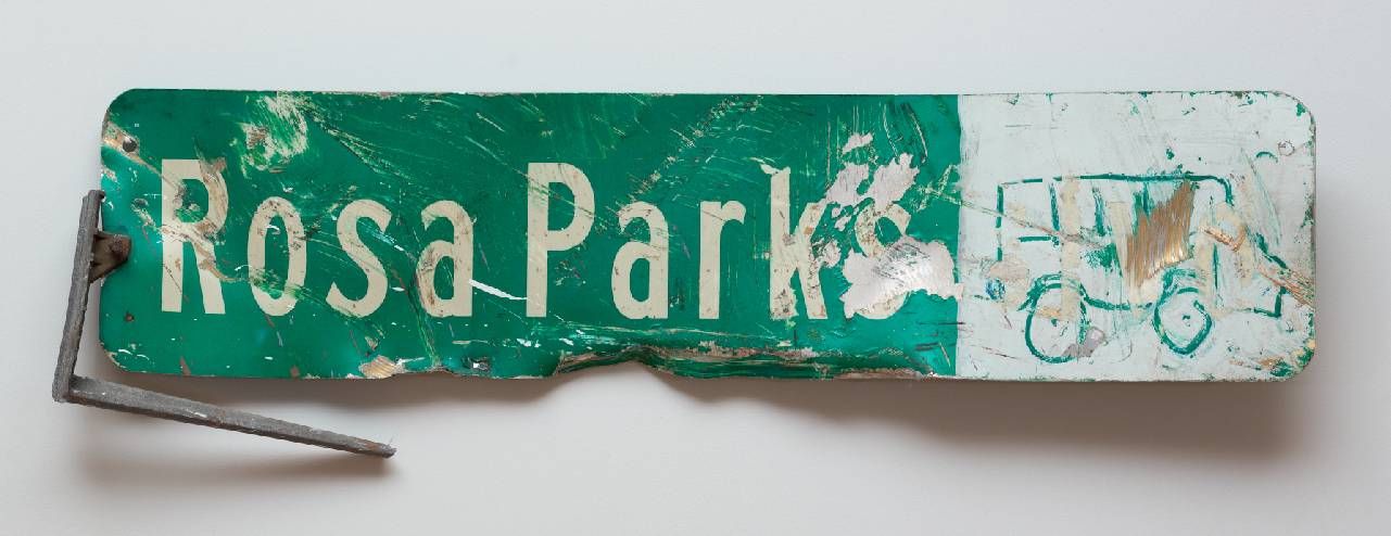 A photograph of a distressed street sign that says, "Rose Parks" Next Avenue