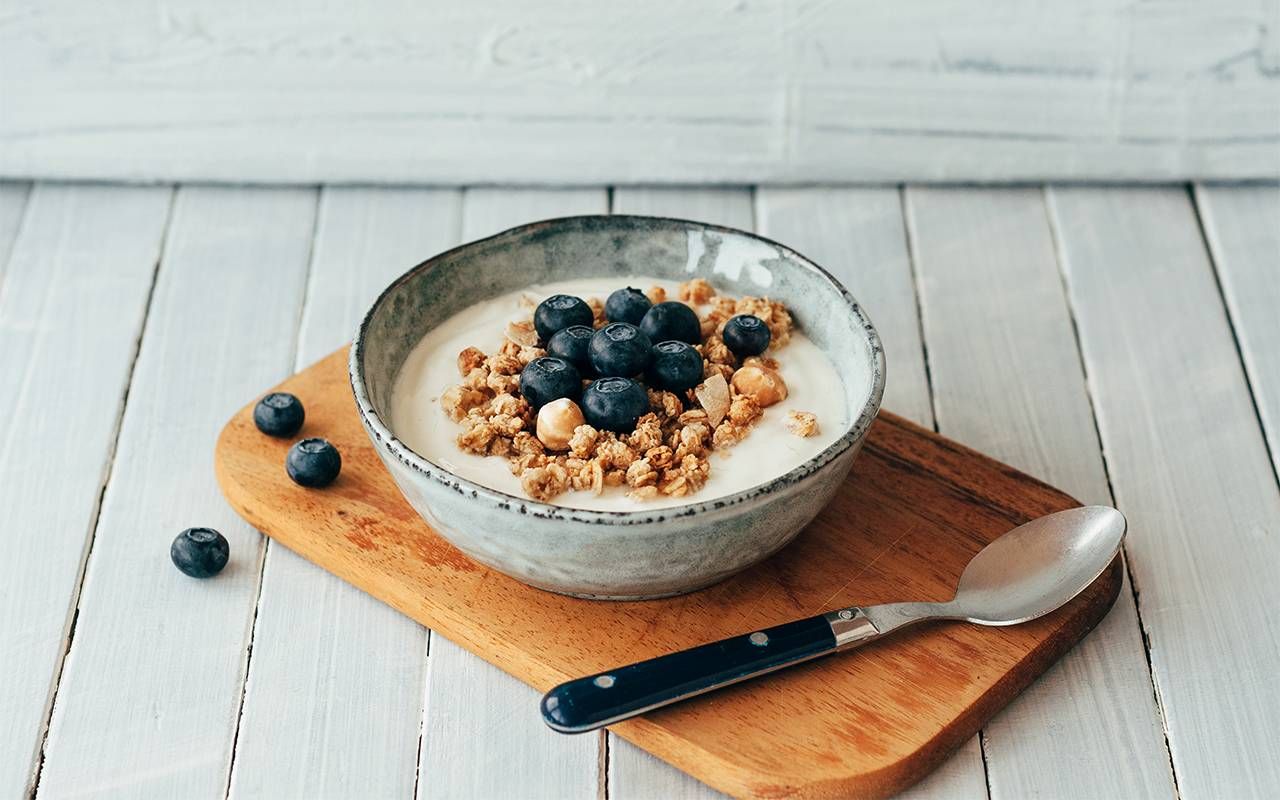 A bowl of yogurt with blueberries and granola. Next Avenue, benefits, probiotics, prebiotics