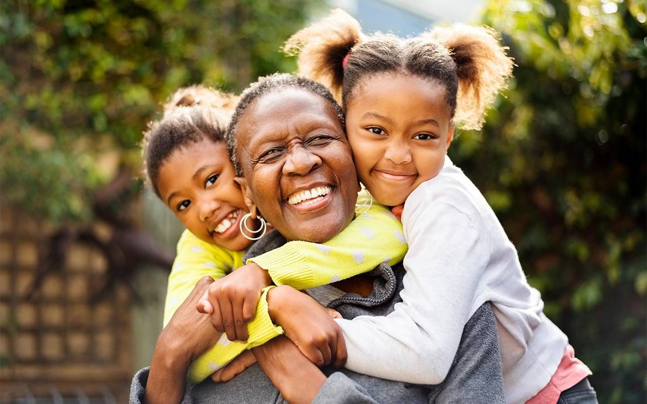 A grandmother hugging her granddaughters. Next Avenue