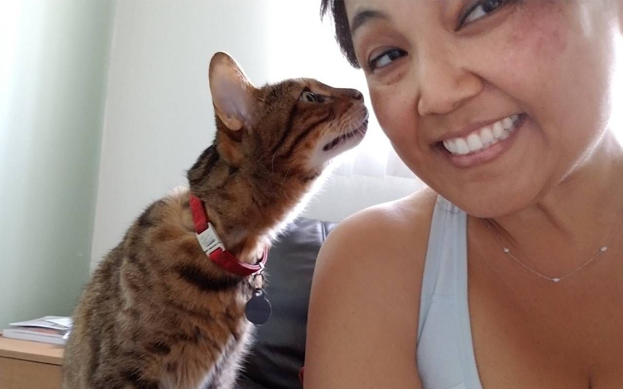 A woman smiling with her pet cat. Next Avenue, losing a pet, grieving a pet