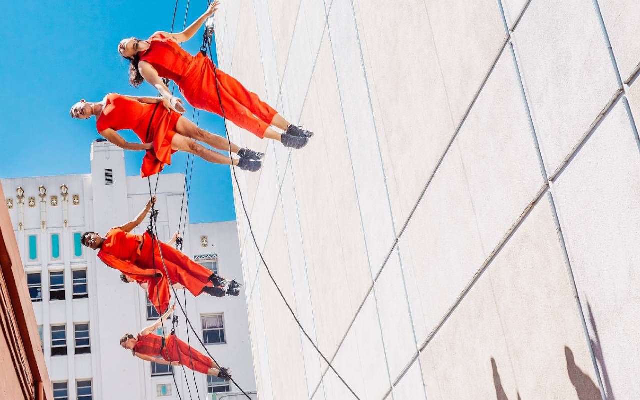 A group of people propelling off of an exterior wall. Next Avenue, Santa Cruz Museum of Art and History