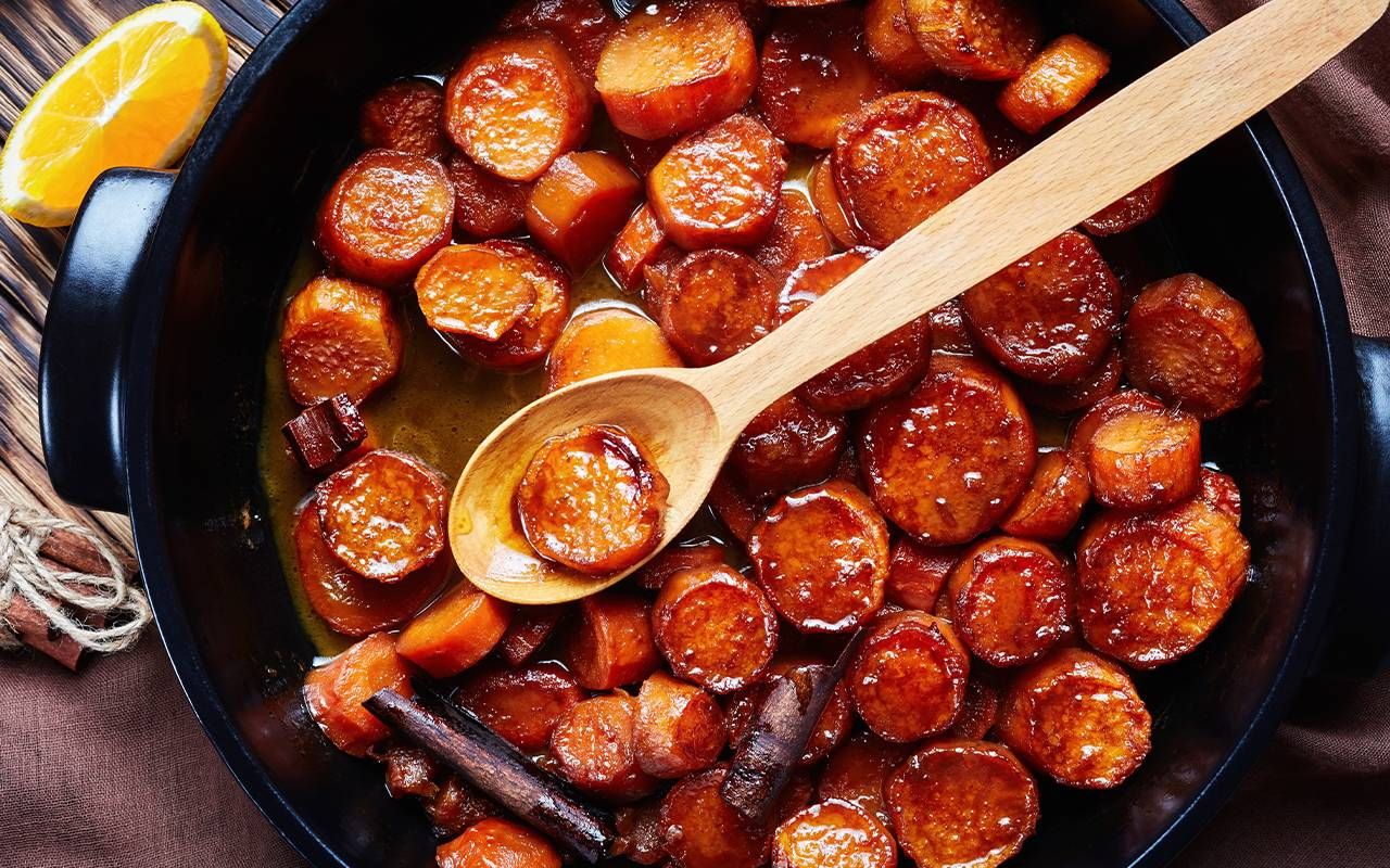 candied sweet potatoes cooking in a cast iron pan. Next Avenue, recipe