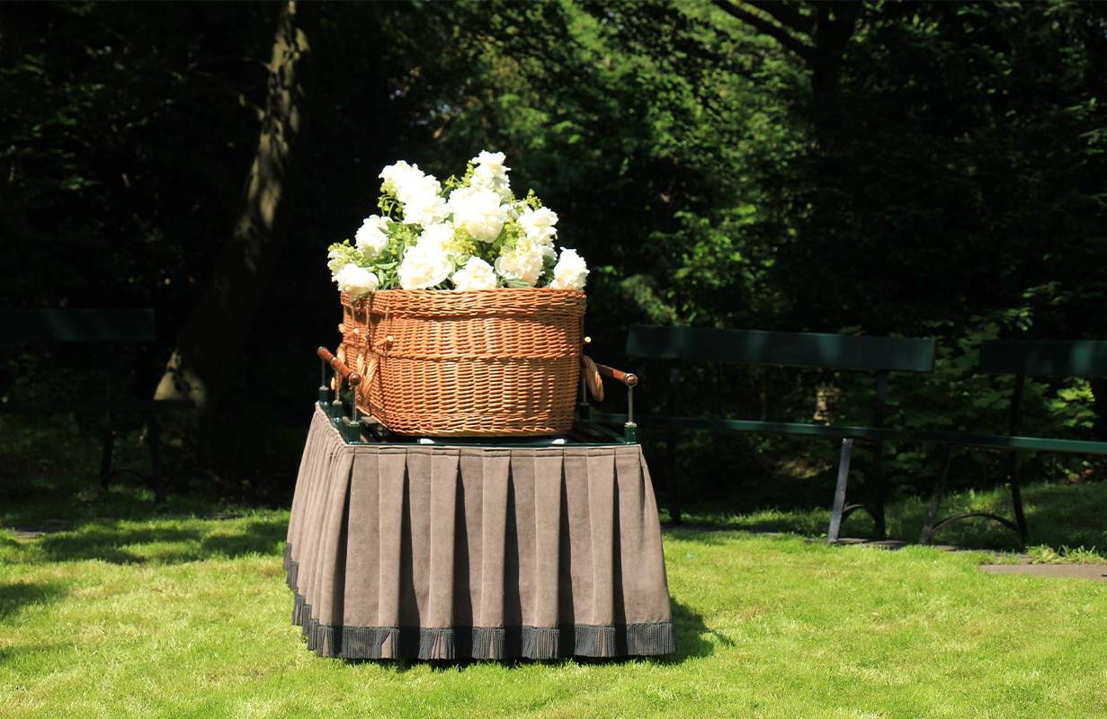 A woven casket with flowers on top of it. Next Avenue, non traditional burial options