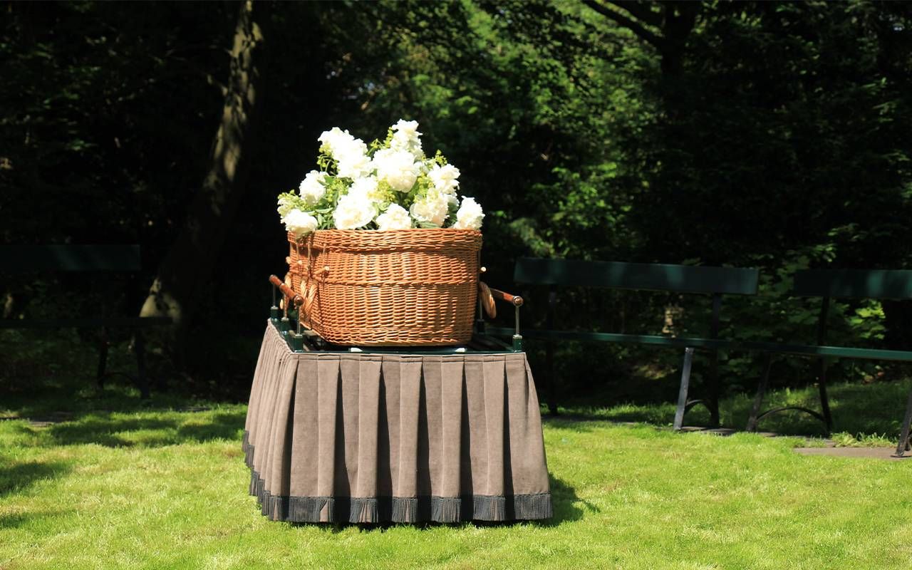 A woven casket with flowers on top of it. Next Avenue, non traditional burial options
