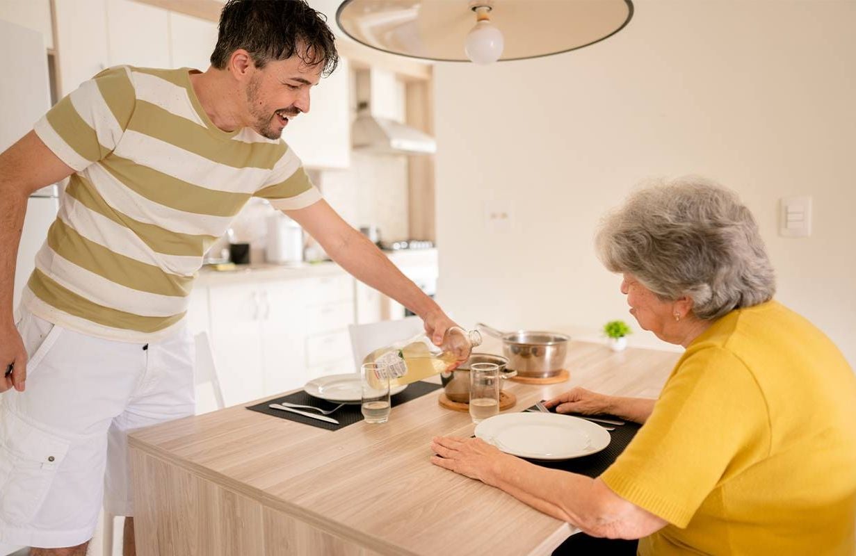 An adult son making food for his mother with dementia. Next Avenue