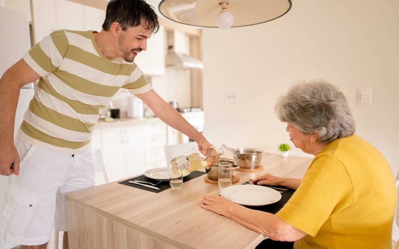 An adult son making food for his mother with dementia. Next Avenue