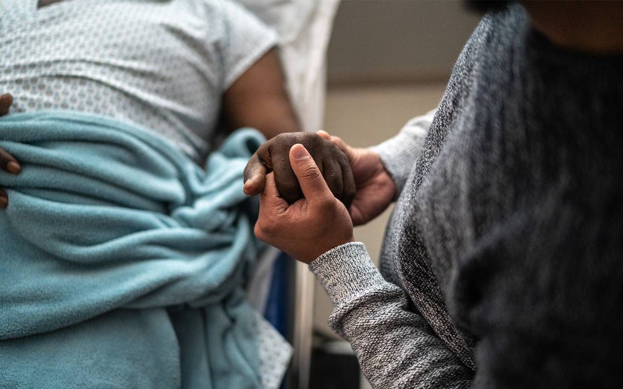 An adult child holding their parent's hand. Next Avenue, Parkinson's disease
