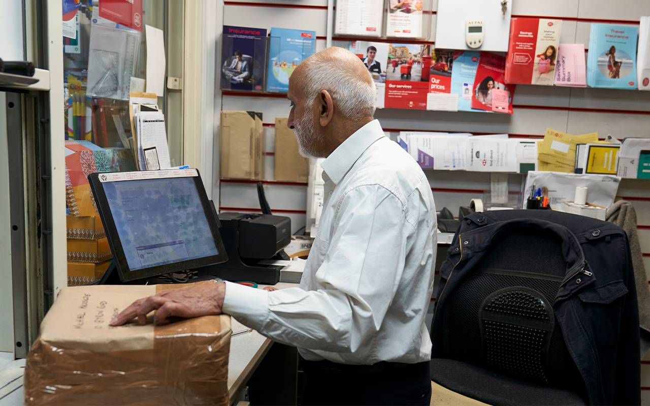 An older post office worker on the job. Next avenue, aging workforce, older workers
