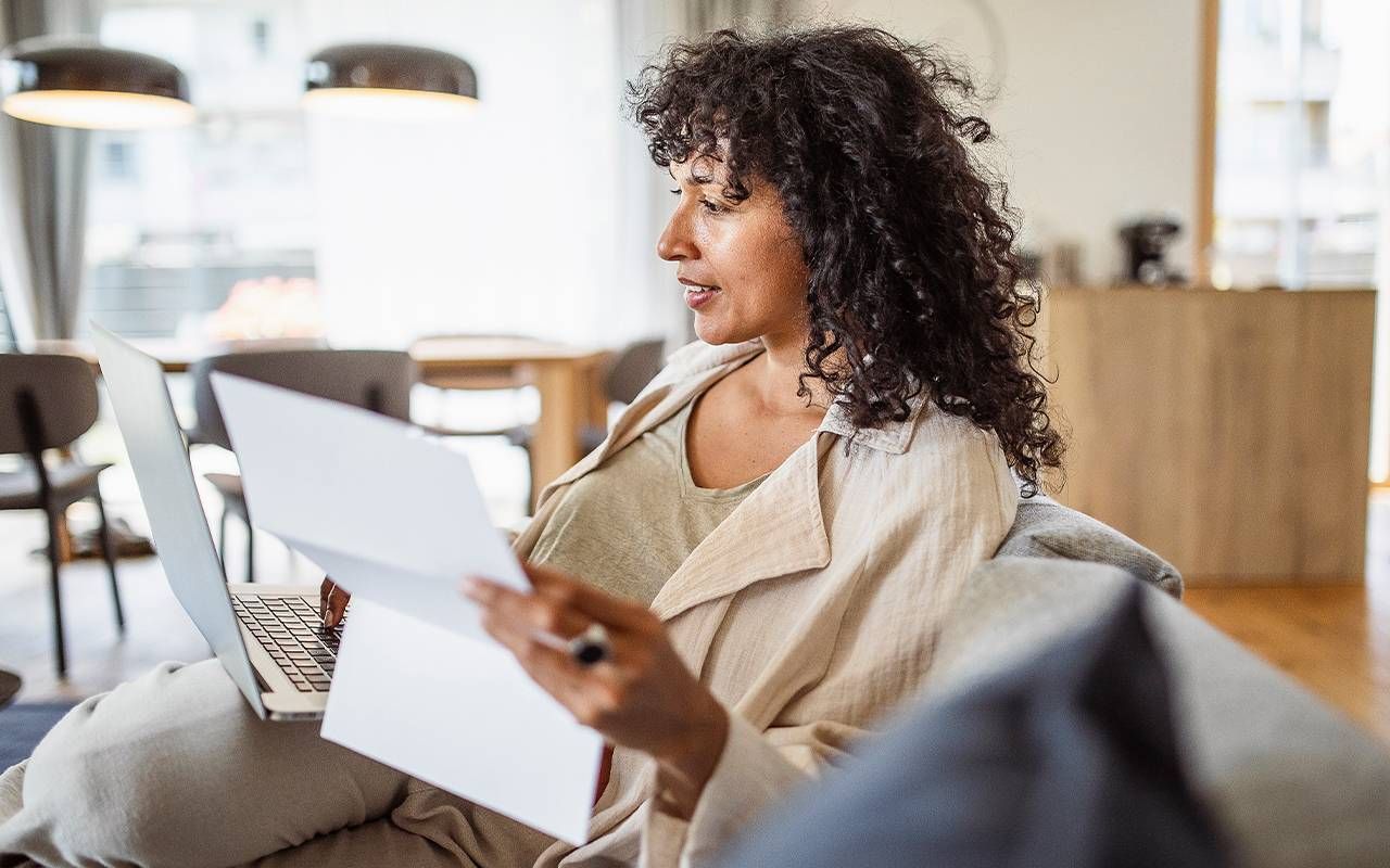 A woman looking over her credit card statement. Next Avenue, money saving tips