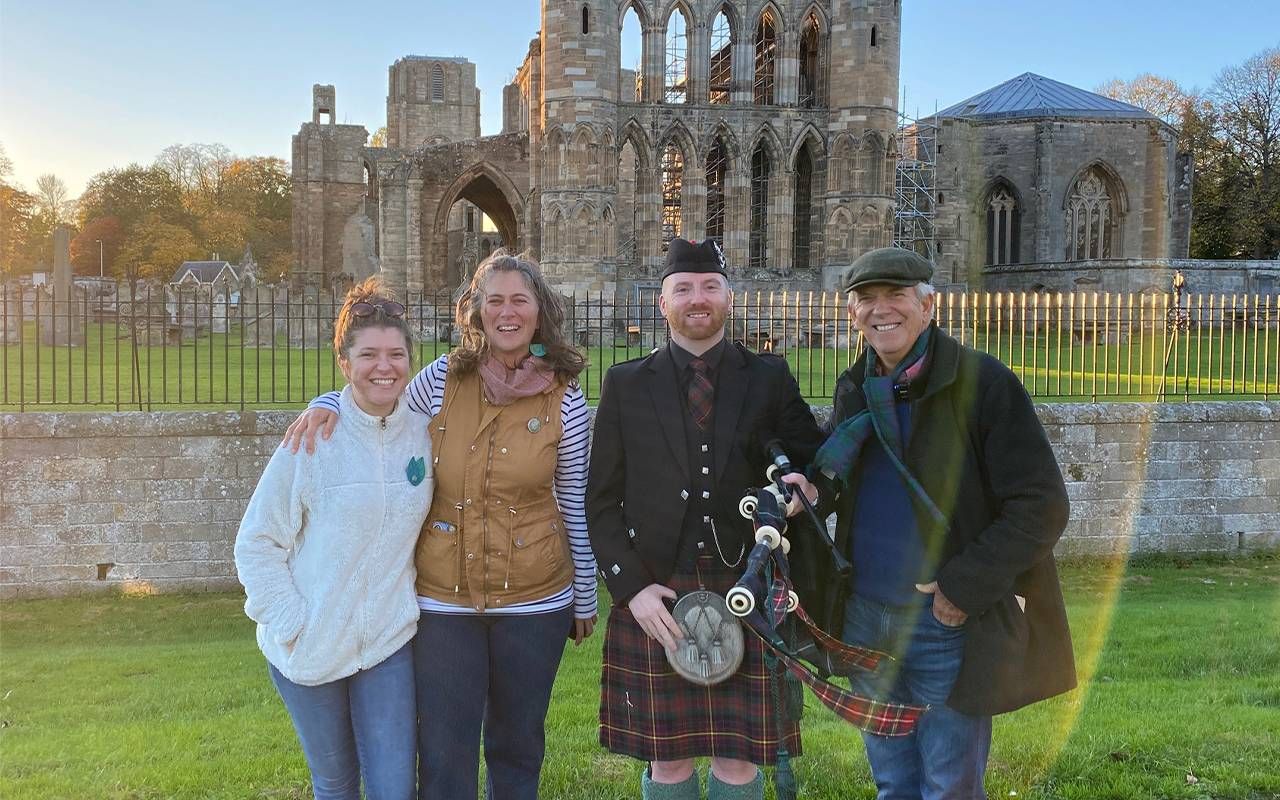 A group of people smiling in front of cathedral ruins. Next Avenue, visiting ancestral land, family genealogy, family history