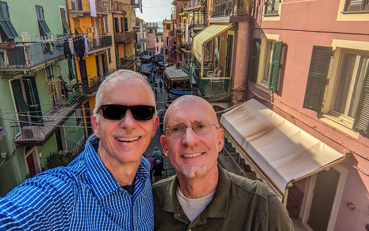 Two people taking a selfie in a historic town. Next Avenue travel and work