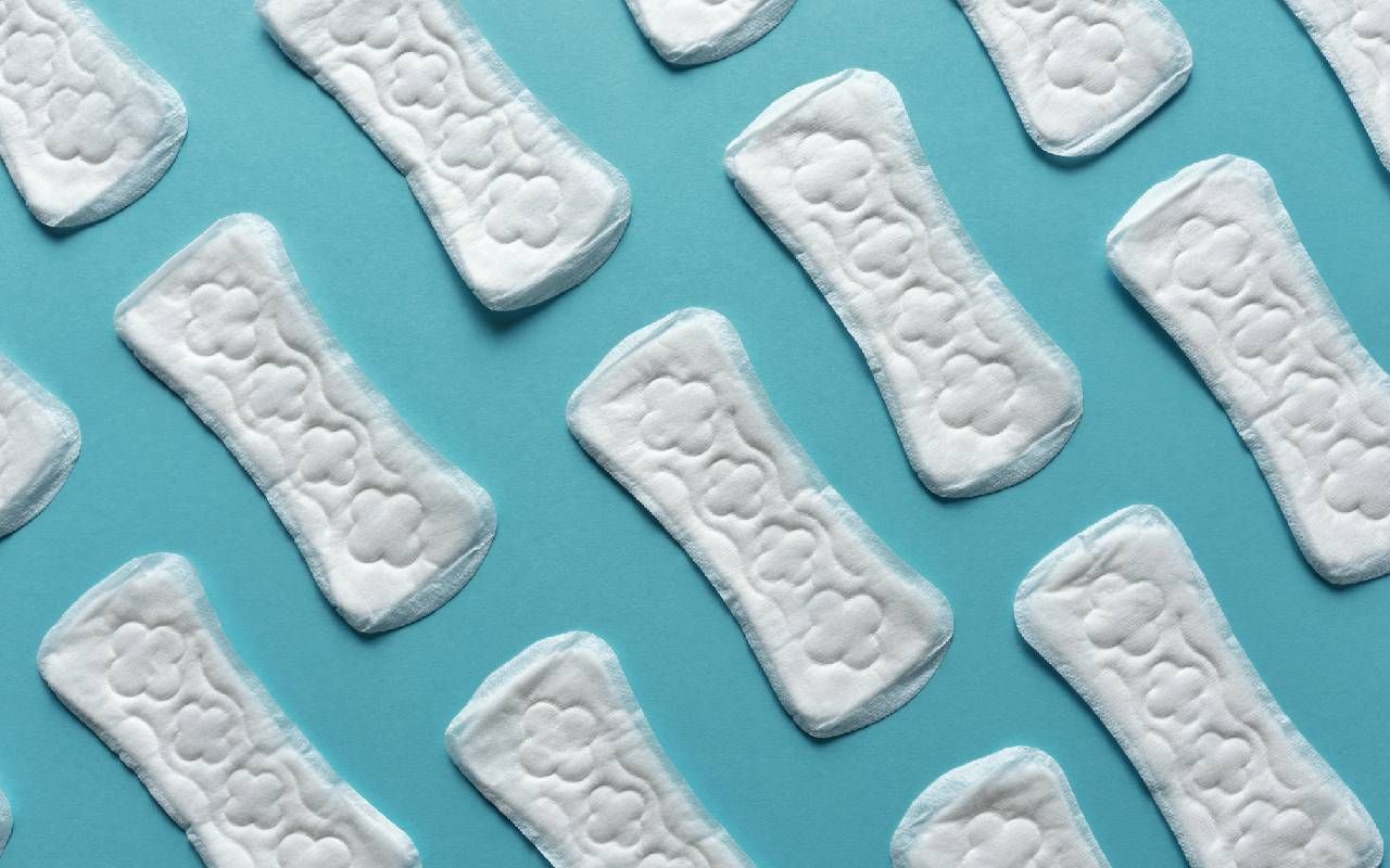 several sanitary pads lined up on a background. Next Avenue, menstruation, periods