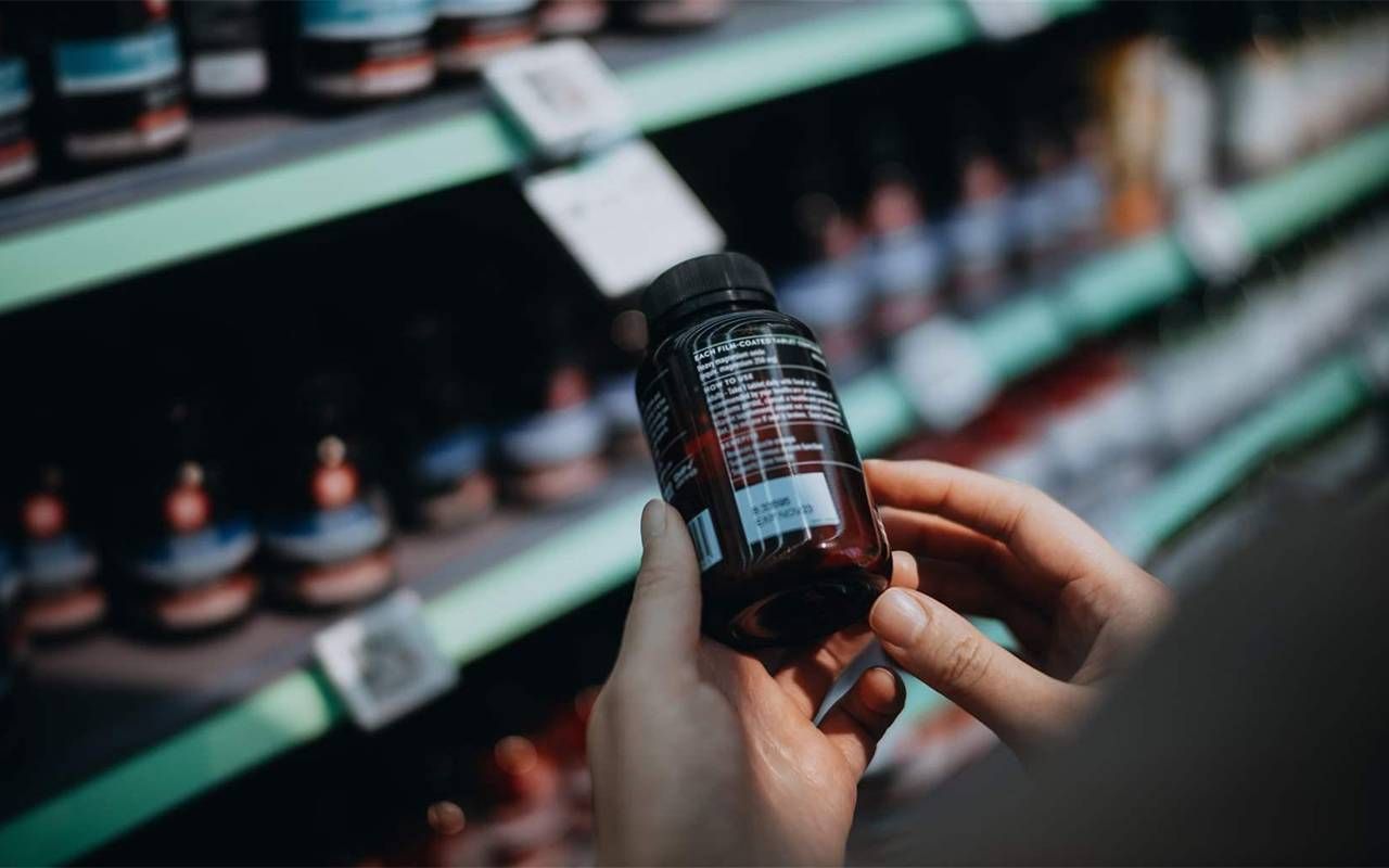 A person reading the safety label of an herbal supplement. Next Avenue, non-traditional treatments for menopause