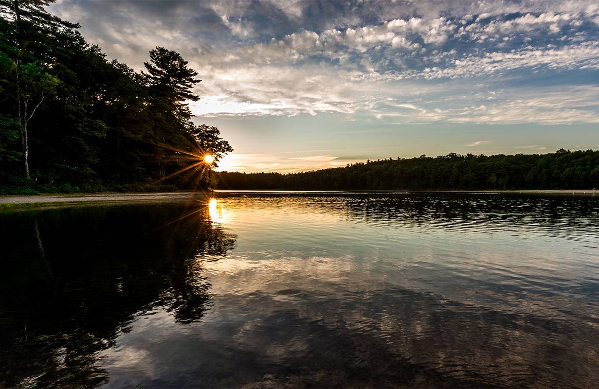 A glistening lake at sunset. Next Avenue, simplicity, declutter, walden pond, Henry David Thoreau