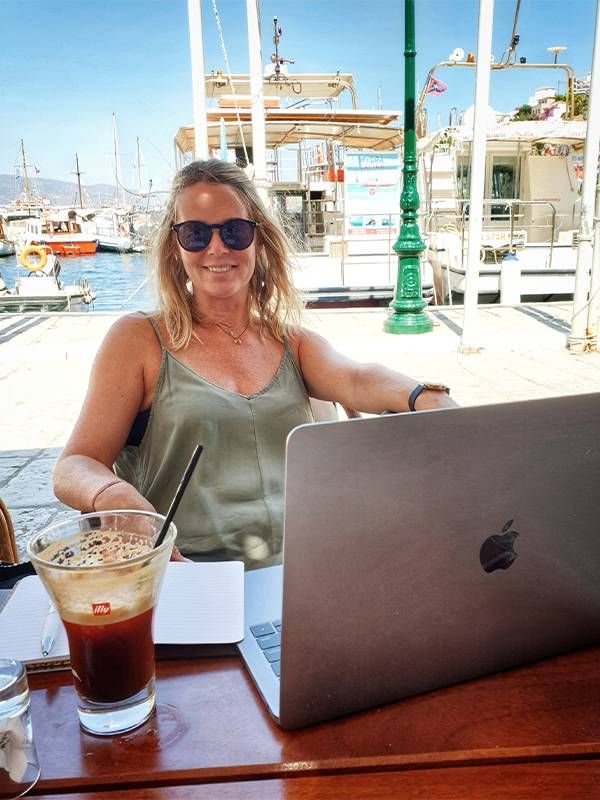 A person sitting at an outdoor cafe. Next Avenue travel and work