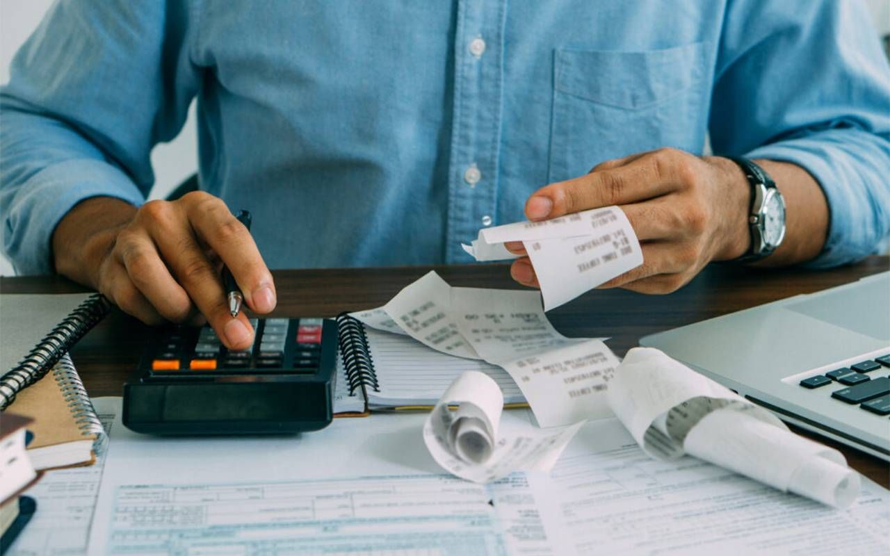 A older persona calculating their tax bill. Next Avenue, can't pay tx bill, owe irs