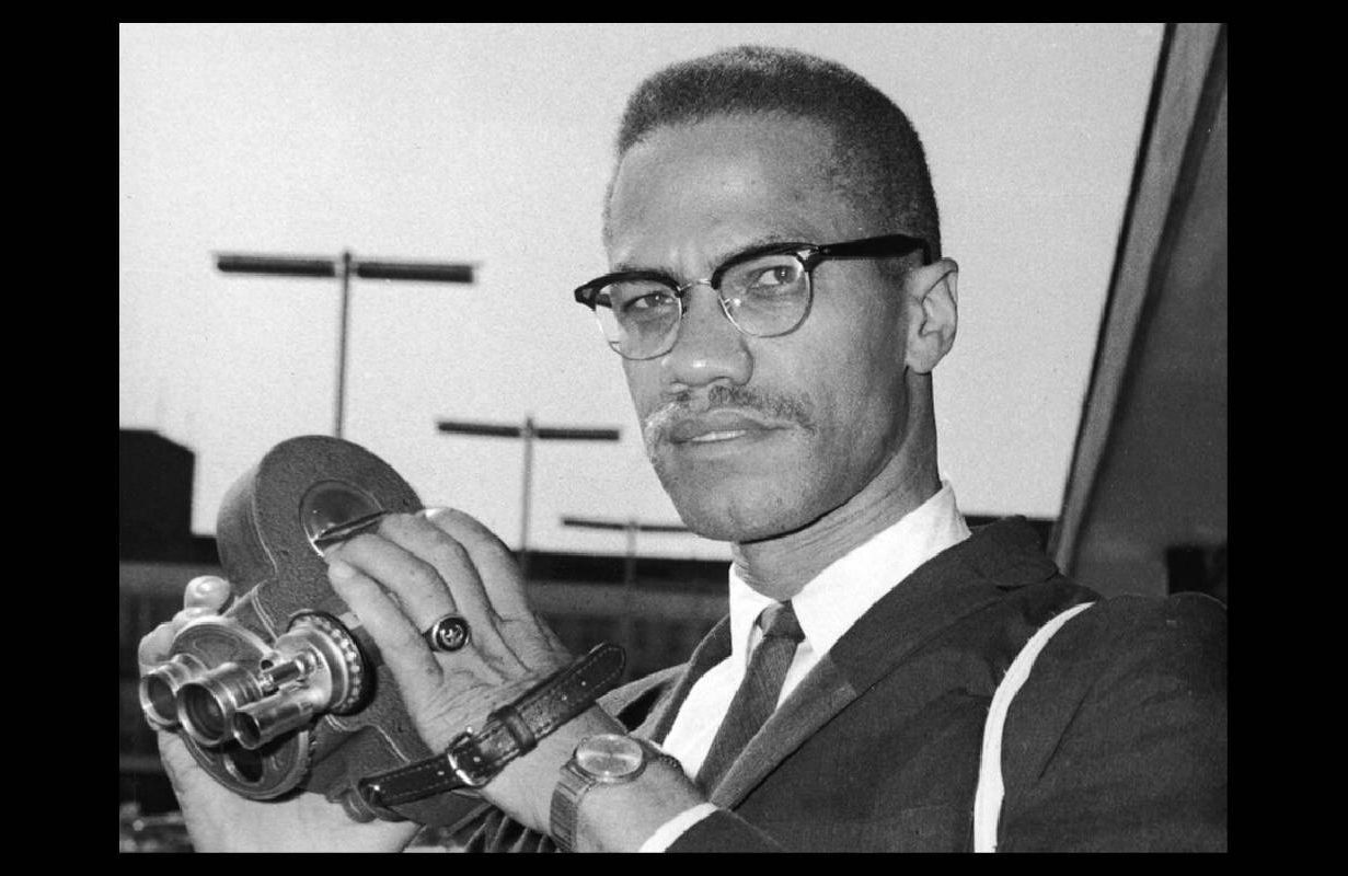 A photo of Malcolm X holding an old film camera. Next Avenue, Saying It Loud: 1966 The Year Black Power Challenged the Civil Rights Movement, Mark Whitaker