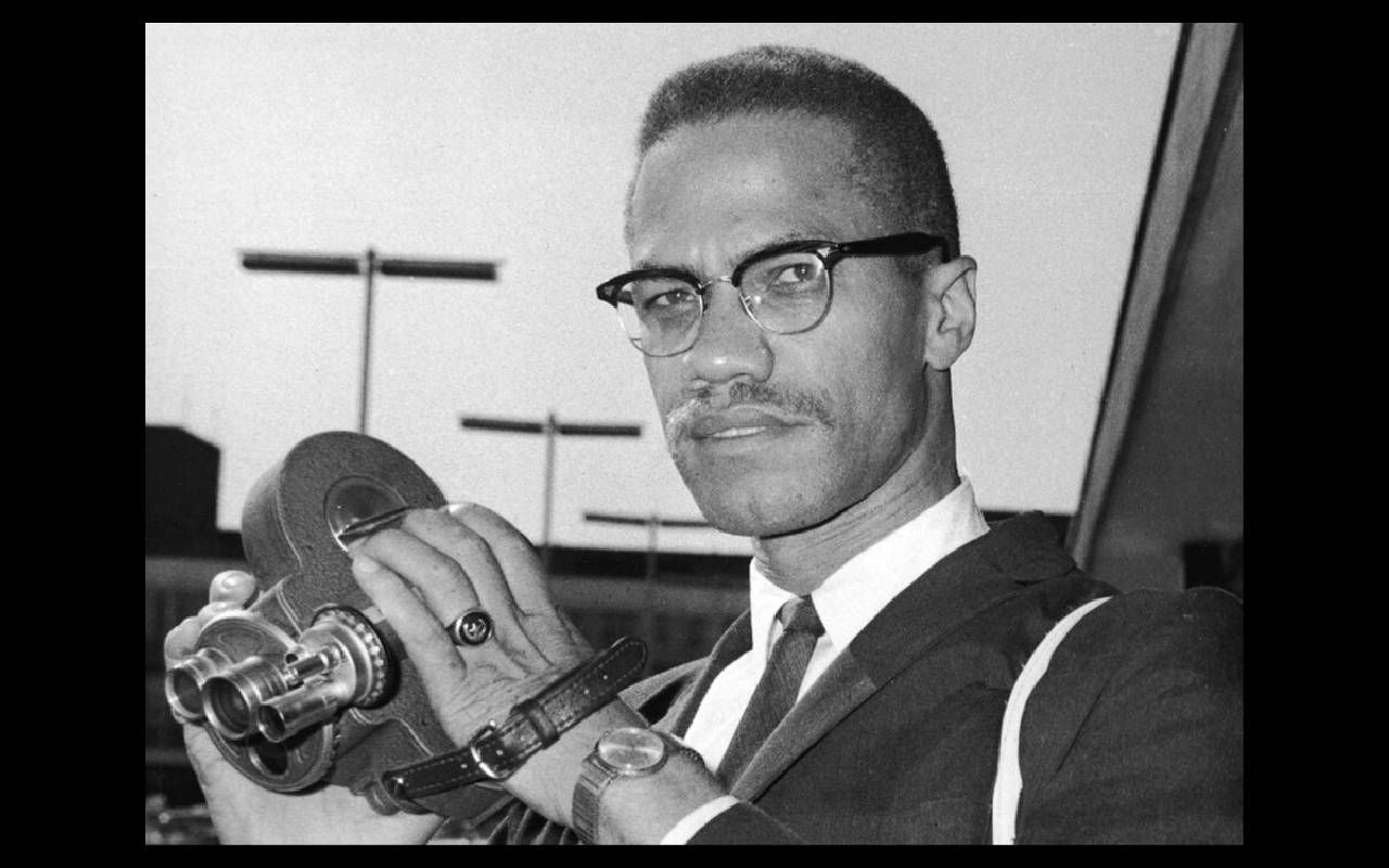 A photo of Malcolm X holding an old film camera. Next Avenue, Saying It Loud: 1966 The Year Black Power Challenged the Civil Rights Movement, Mark Whitaker