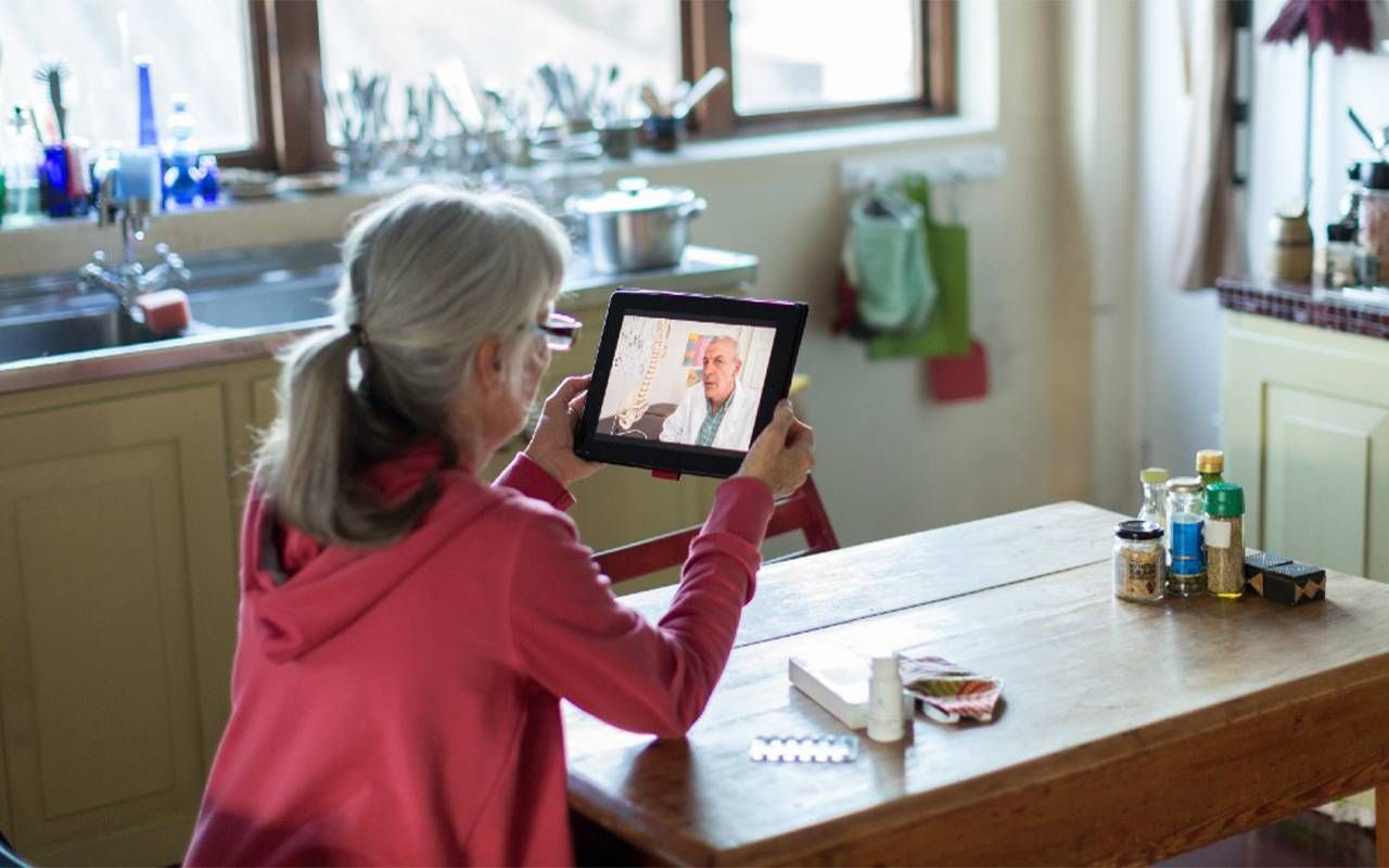 An older adult during a telehealth appointment at home. Next Avenue, virtual appointment, telemedicine