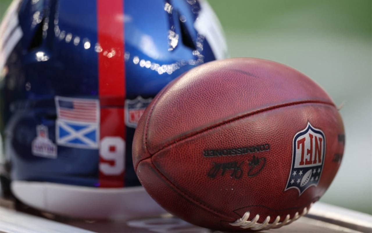 A close-up shot of a football and a helmet. Next Avenue, Next Avenue, A Giant Win, Tom Coughlin