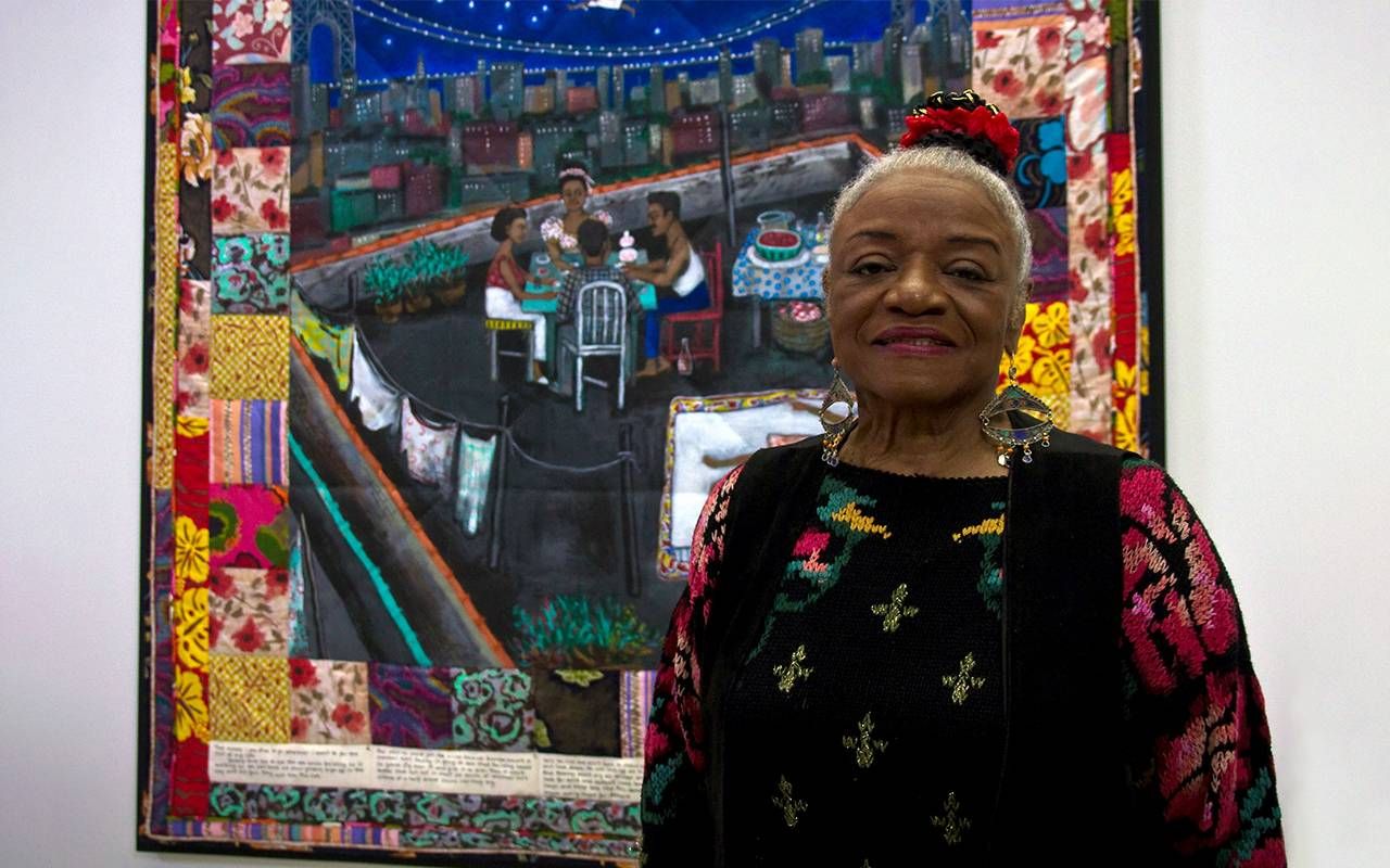 A person standing in front of a quilt. Next Avenue, contemporary quilts, Faith Ringgold