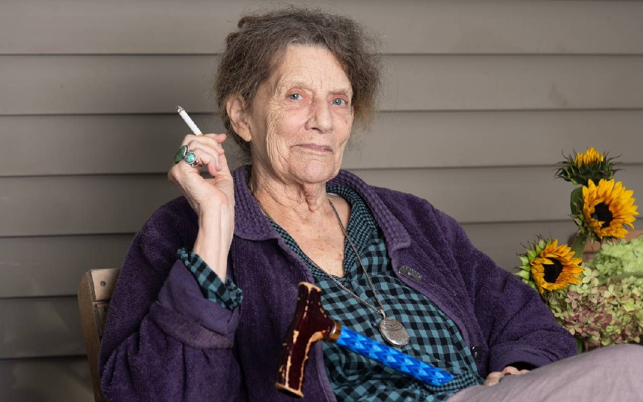 A woman sitting outside smoking a cigarette. Next Avenue, Abigail Thomas