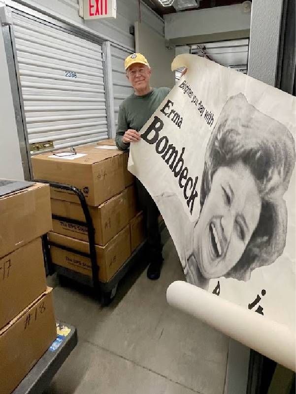 A person holding up an Erma Bombeck poster. Next Avenue