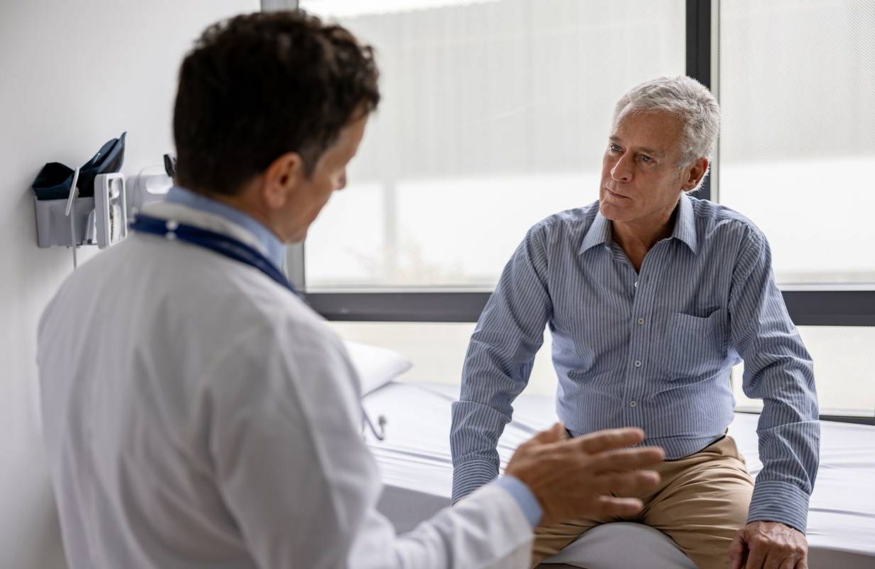 An older adult talking to his doctor. Next Avenue, expat, healthcare