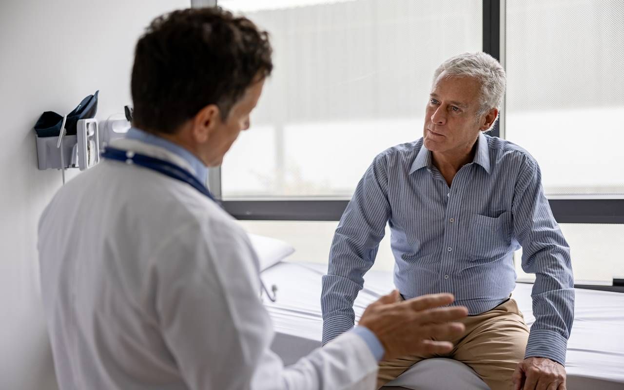 An older adult talking to his doctor. Next Avenue, expat, healthcare