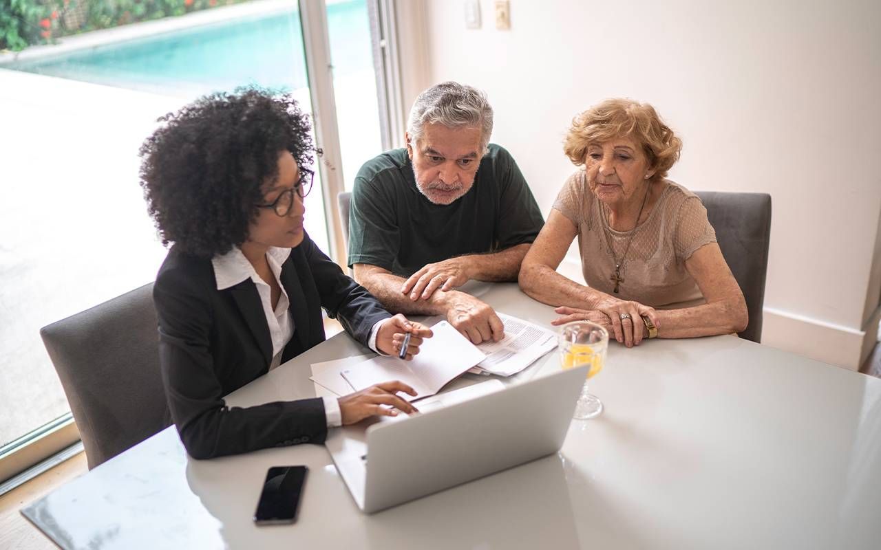 A financial advisor talking to an older couple. Next Avenue, social security