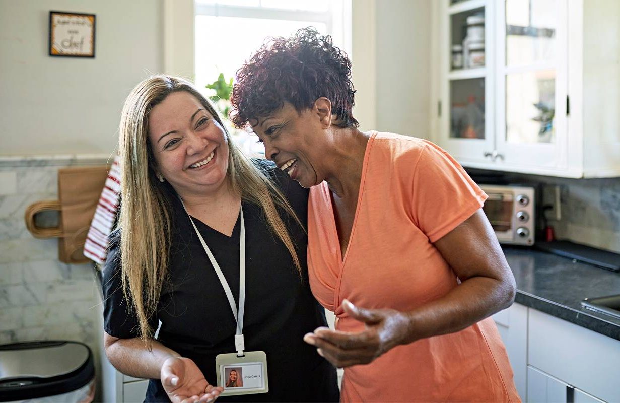 A direct care worker laughing with a patient. Next Avenue, direct care workers