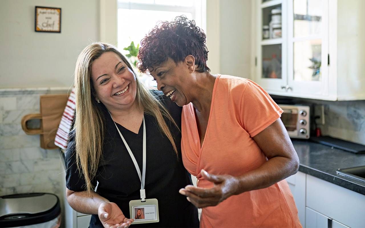 A direct care worker laughing with a patient. Next Avenue, direct care workers