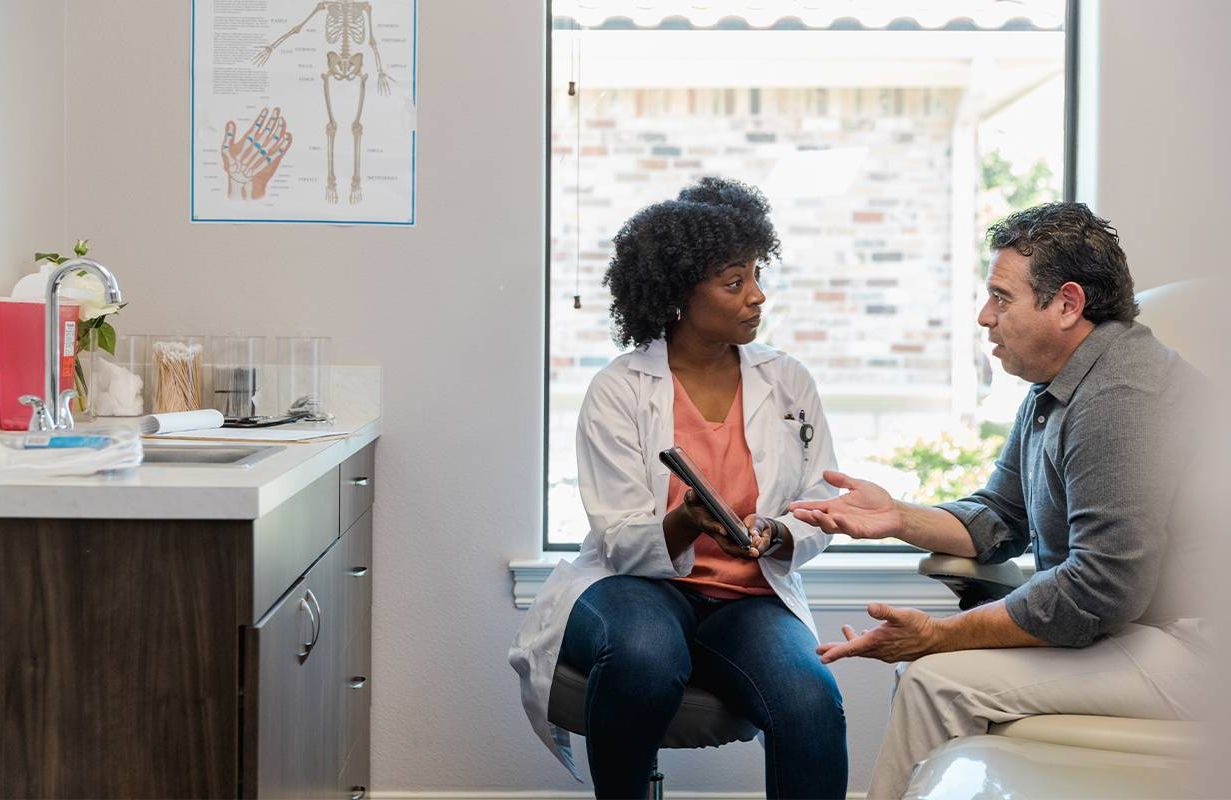 A doctor talking to a patient about anal cancer. Next Avenue
