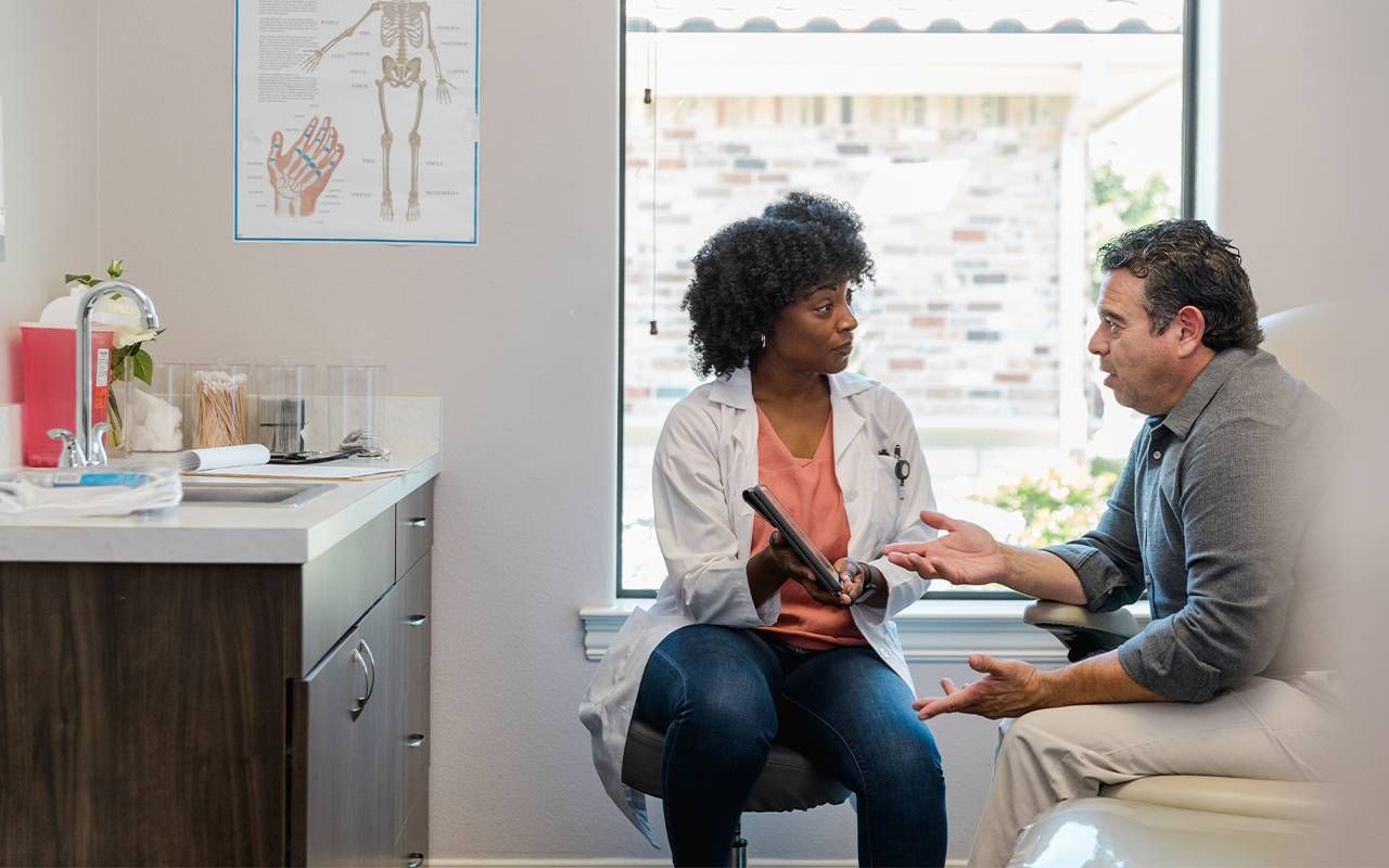 A doctor talking to a patient about anal cancer. Next Avenue