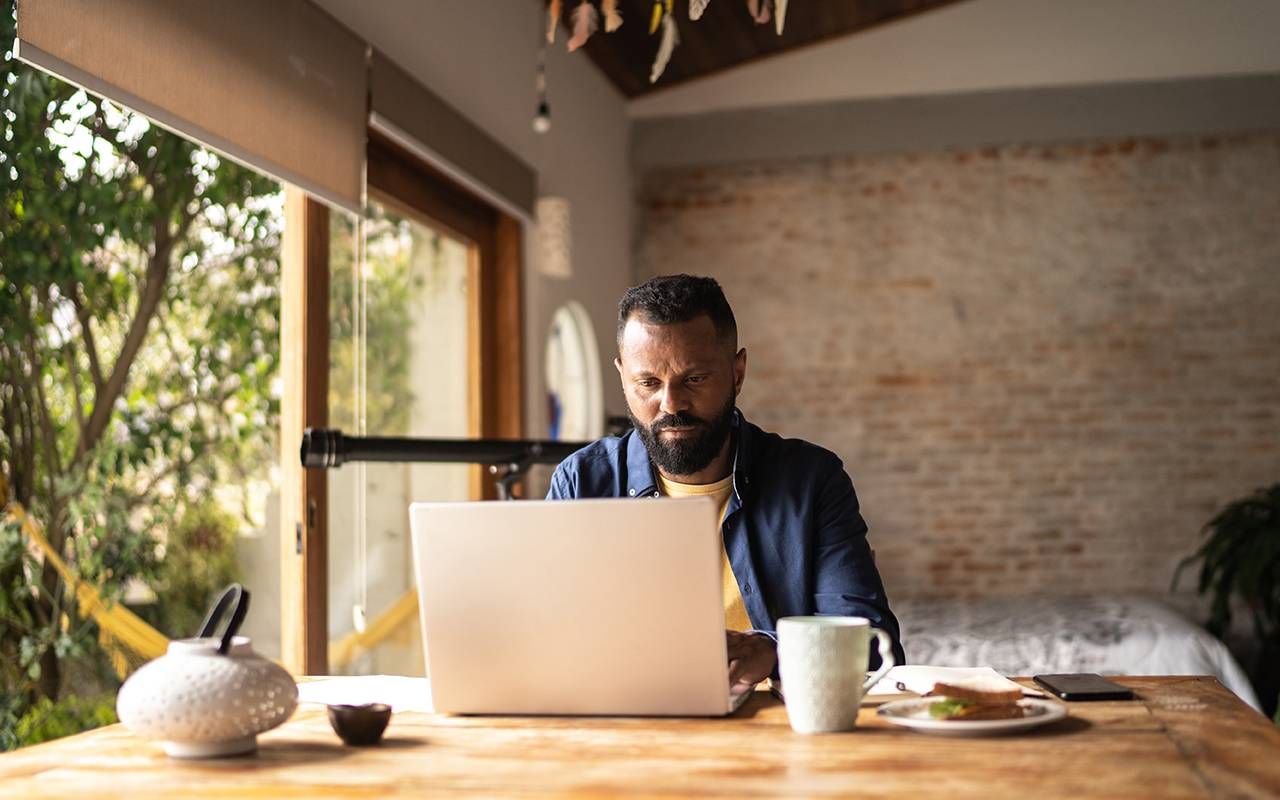 A man using his computer at home. Next Avenue, layoff, laid off, LinkedIn