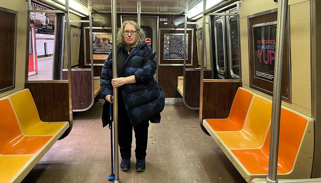 A person with a cane standing on the subway. Next Avenue, cane, accessibility, nyc